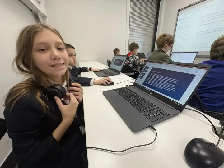 Школьник за ноутбуком в наушниках выполняет IT-задание