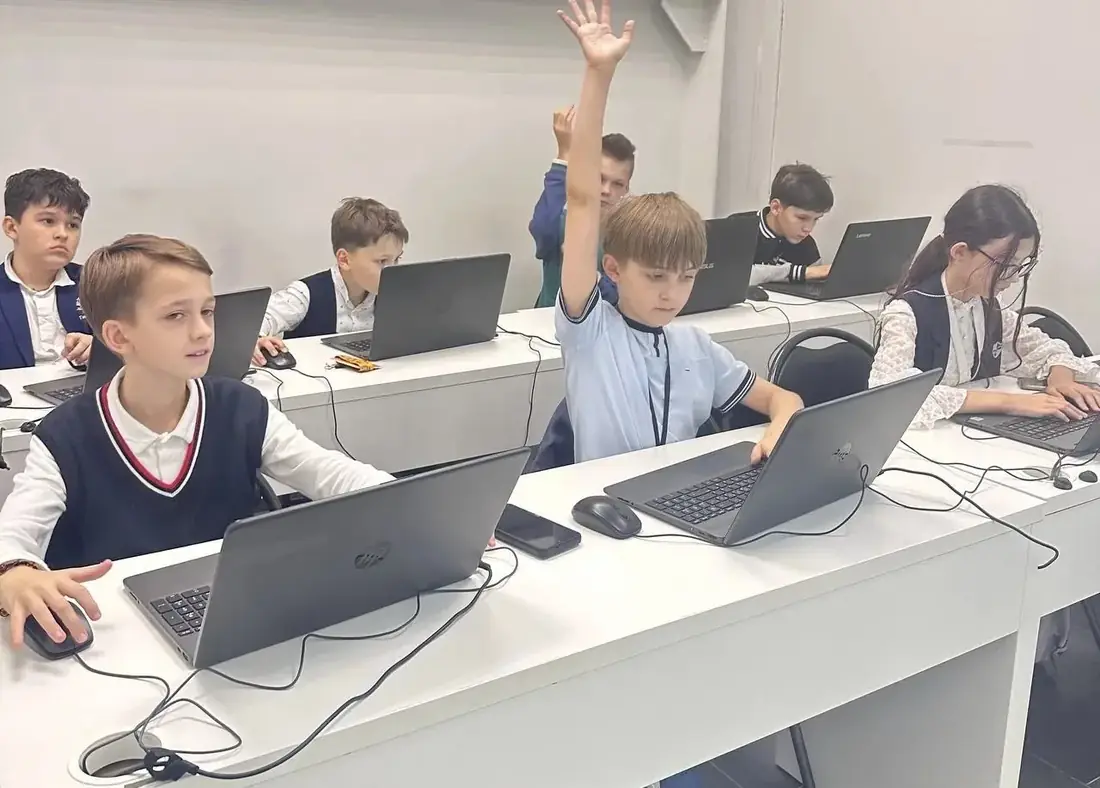 Ребёнок на IT-занятии поднимает руку в классе Технопарка